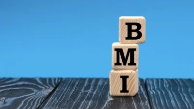 A wooden block with the word bmi stacked on top of it showcases the consequences of an imbalanced BMI.