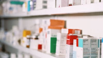 Amycretin medication boxes lined up on pharmacy shelves.