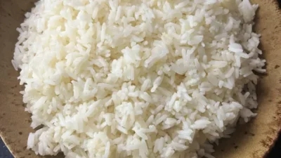 A bowl of rice, good for weight loss, on a dark surface.